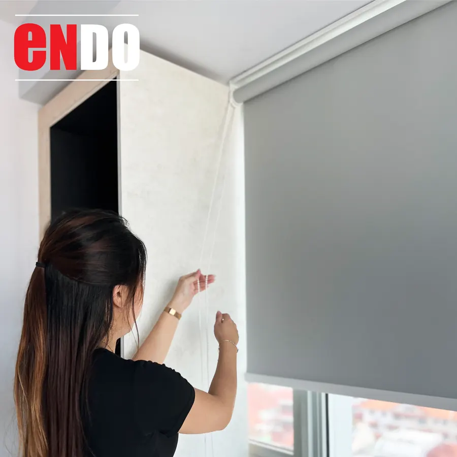 Blackout roller blind installation in Singapore home, grey fabric