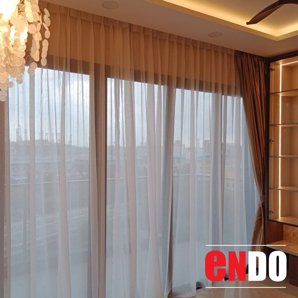 Day and night curtains installed on large floor-to-ceiling windows in a living room with chandelier