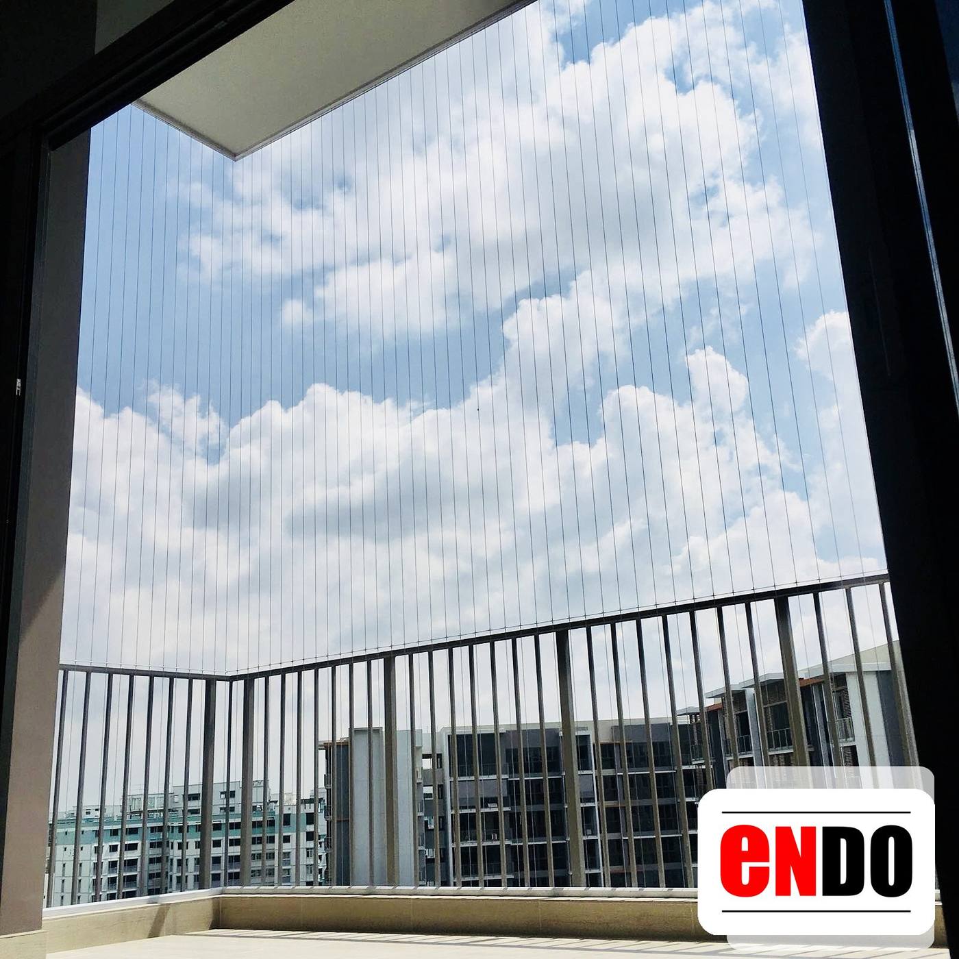 Invisible grille balcony corner view overlooking nearby HDB blocks under blue sky