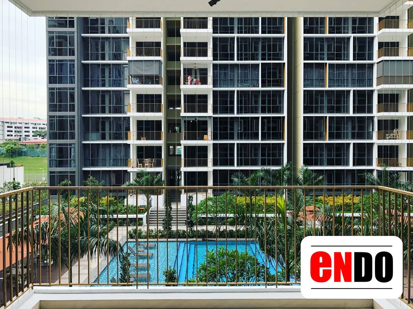 Condo balcony with invisible grille installed, overlooking swimming pool and landscaped garden