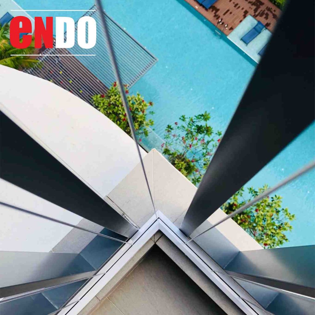 Close-up of invisible grille cables at a condo balcony corner overlooking the pool