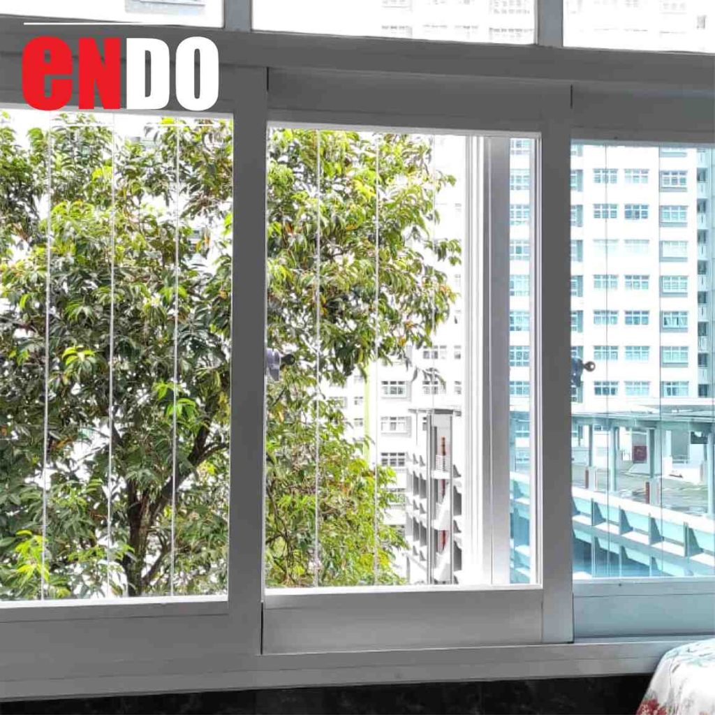 Invisible grille on bedroom sliding windows with a tree-lined view