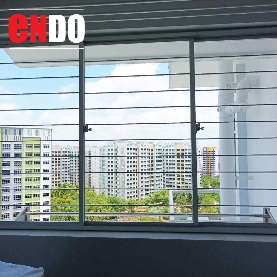 Window security sleek grille installation with blue sky and HDB block view